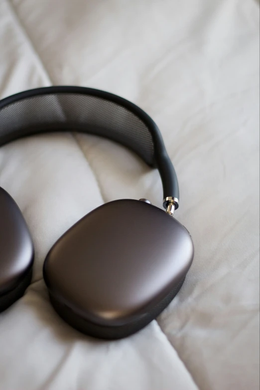 a black headphone laying on top of a white bedspread