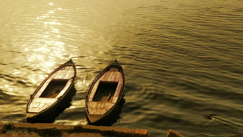 two wooden boats are docked to the dock