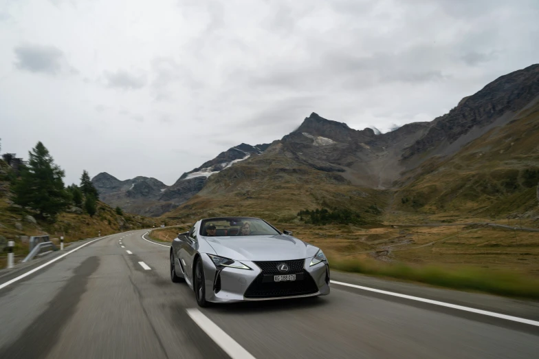 a silver sports car driving on the highway