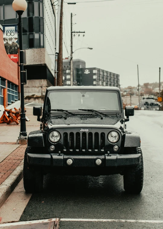 a black jeep is parked on the side of the street