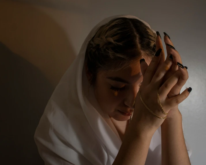 a woman in a veil covering her eyes