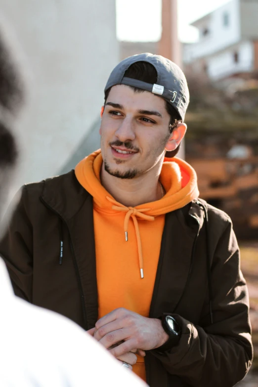 a man with a cap on is looking at another guy