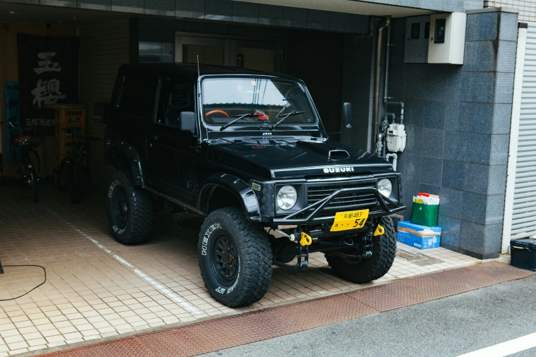 the vehicle is parked in a garage beside the bike rack