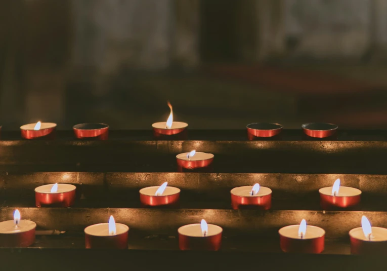 many lit up candles on a metal tray