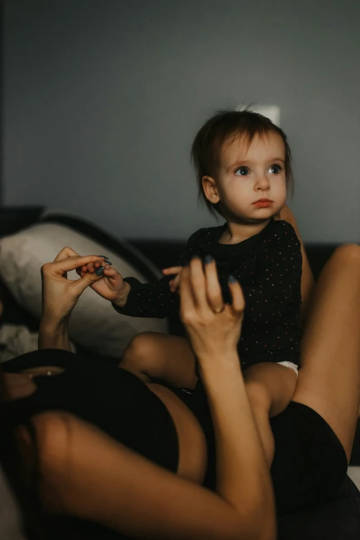 a small girl on a bed holding a phone