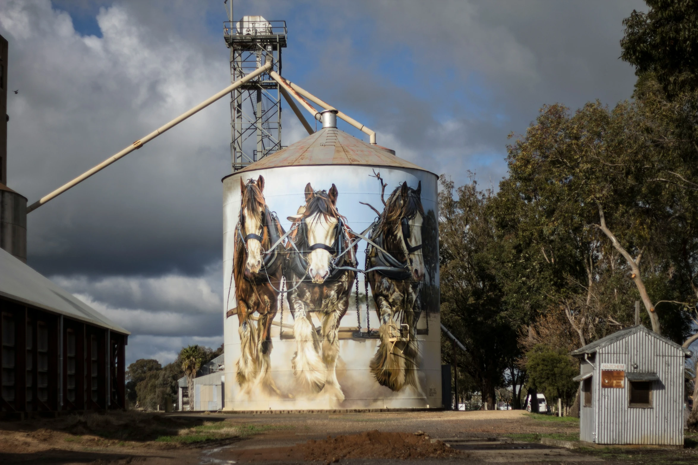 large silos with painted horses and a sky background