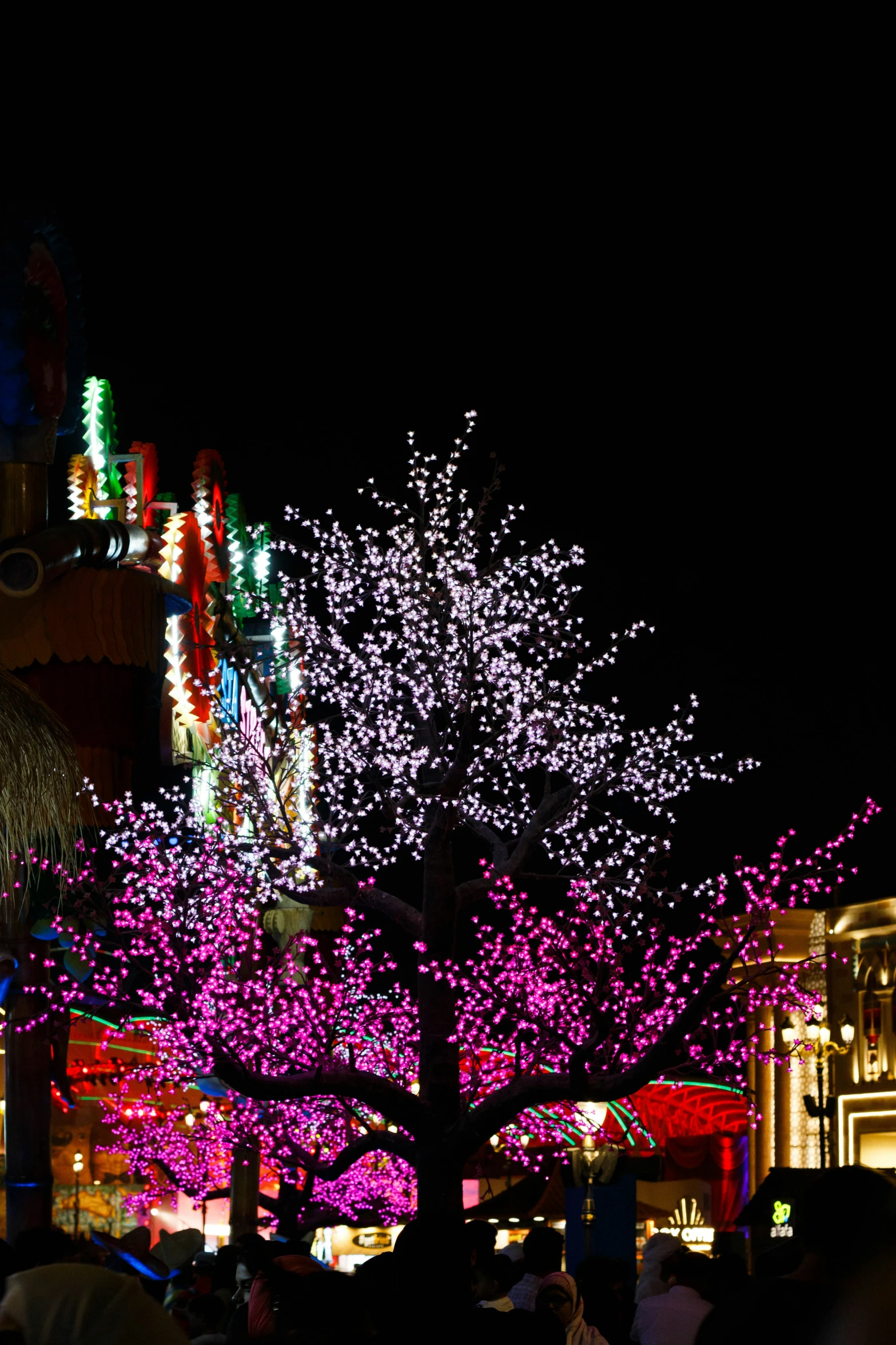 some colorful lights some trees and buildings