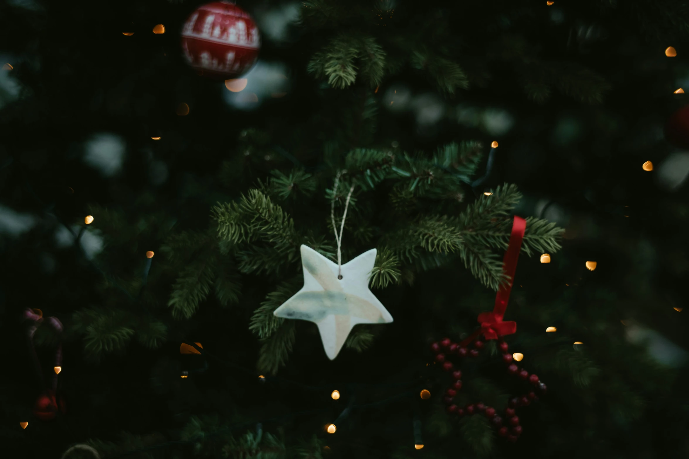 a christmas tree with a white ornament on it