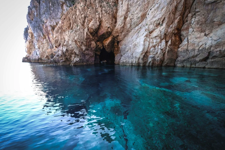 a very narrow and rocky area with clear blue water