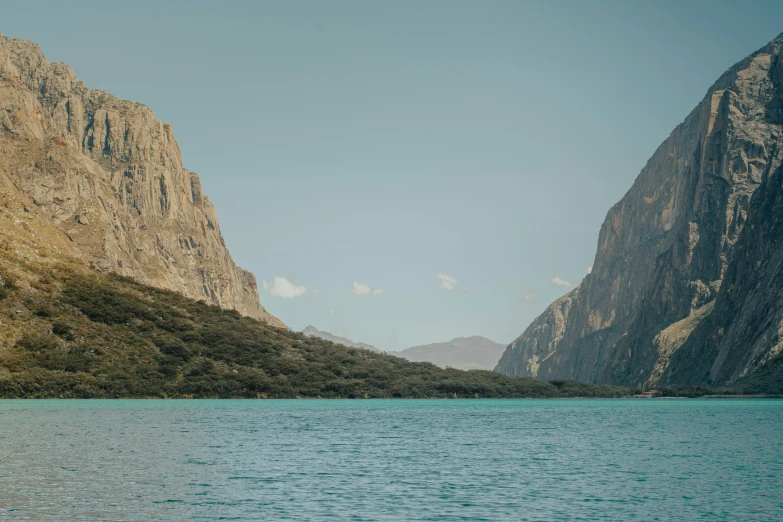 a mountain cliff with a lake below