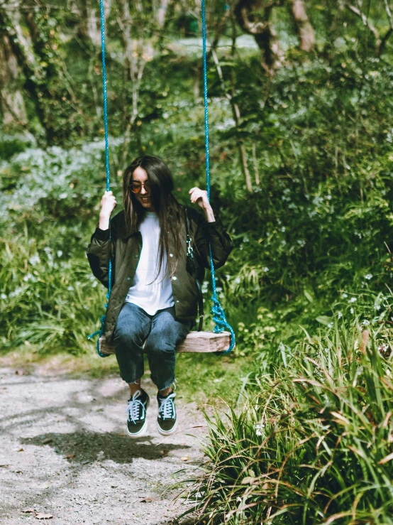 a person in a jacket sitting on a swing