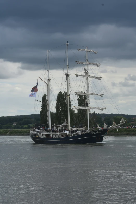 a large sail boat on a lake by a small island