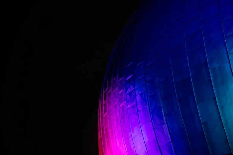 a large colorful sculpture is in the middle of a dark night