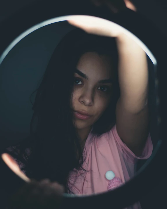 a woman looking into a mirror with her hand on her head