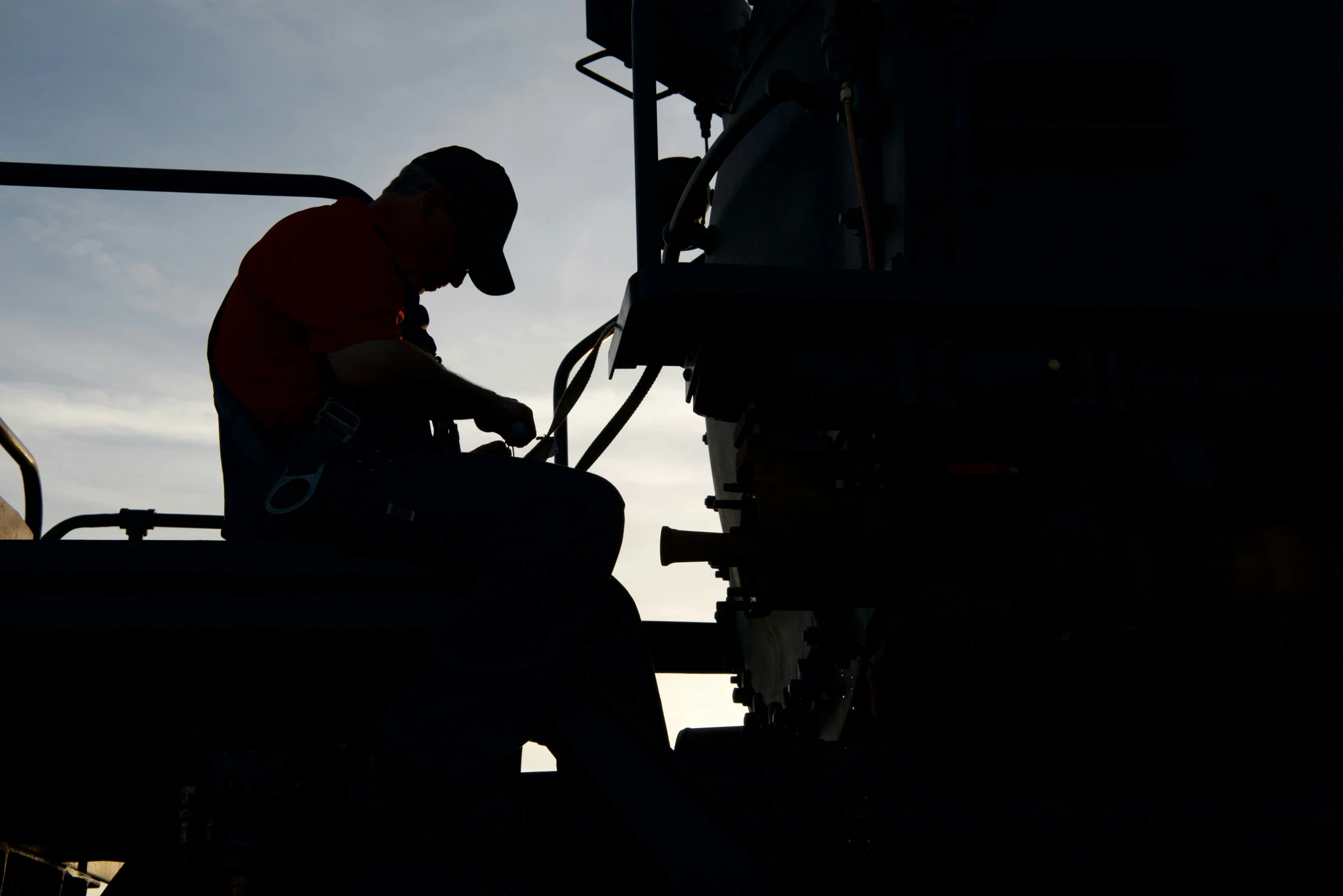 silhouette of a man on a farm machinery