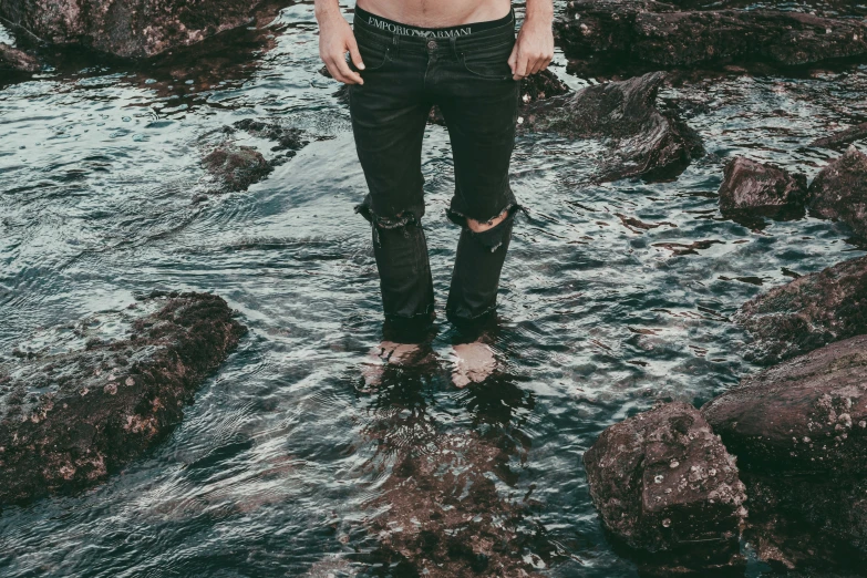 the man is standing in a stream by himself