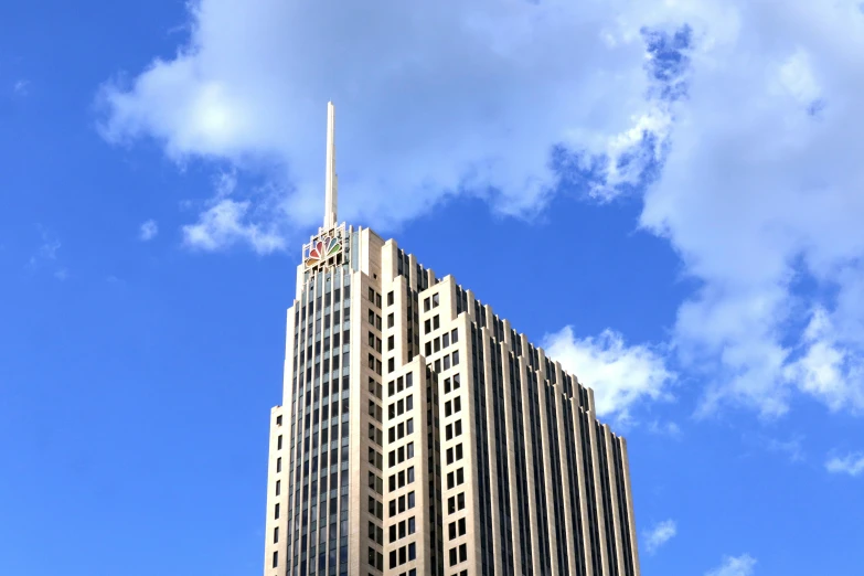 a tall building sitting under a cloudy blue sky