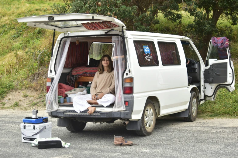 a white van with a bed and two people inside of it