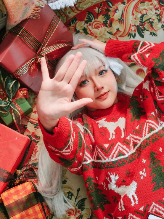 a woman in red is laying down with her hands behind her head and christmas decorations