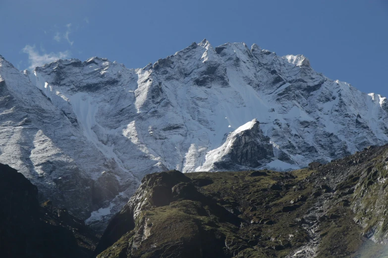 the mountain is covered with snow and grass