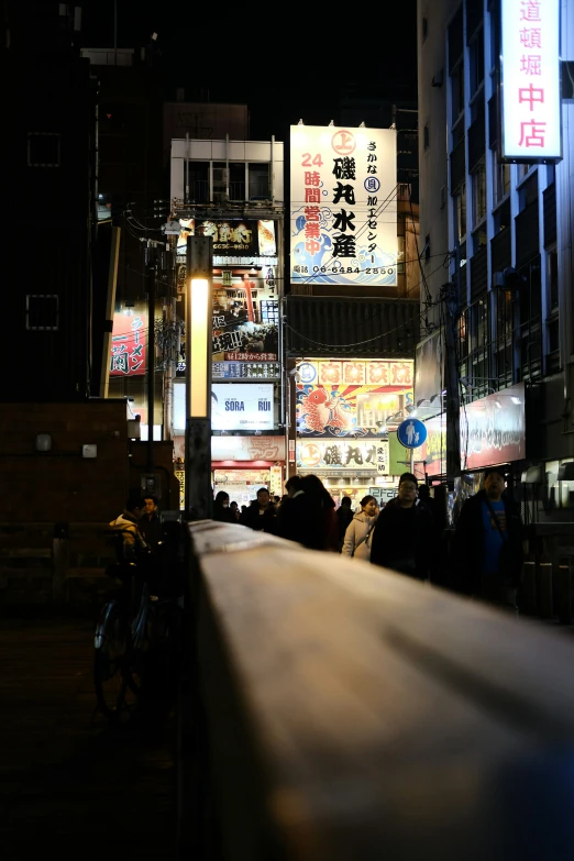 people are walking down the street at night in the city