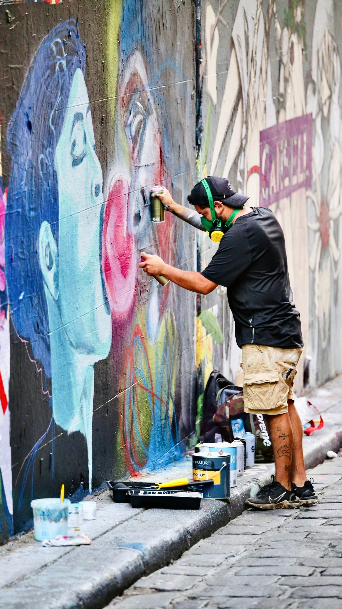 a man is spraying a spray paint on some colorful street art