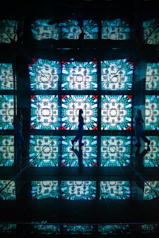 several people stand in a large stained glass window