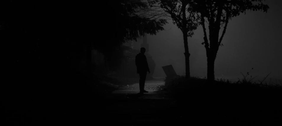 a man stands in the dark by a street light
