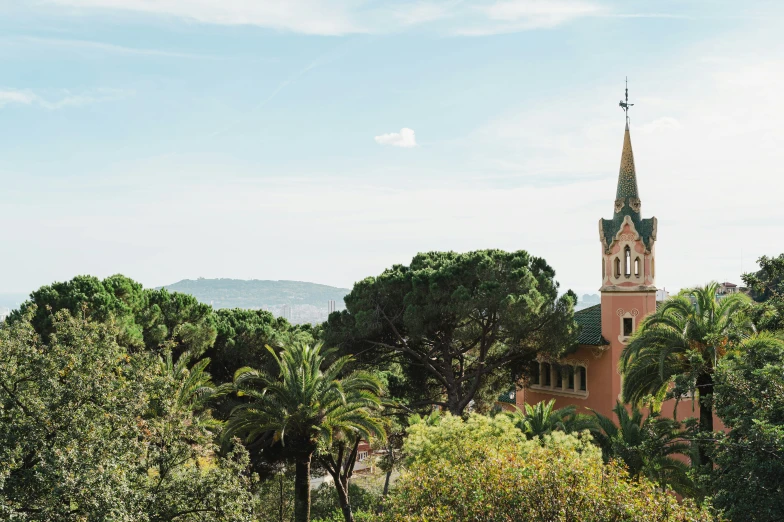 a tall building with a steeple next to some trees