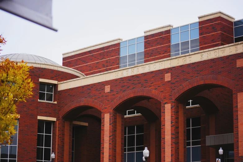 an old red brick building with arches leading to it