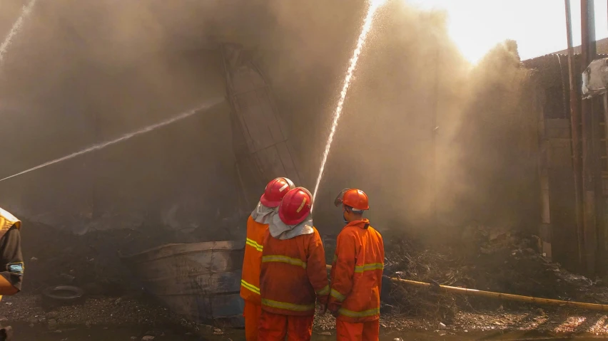 the firefighters are using water hoses to try and extinguise the fire