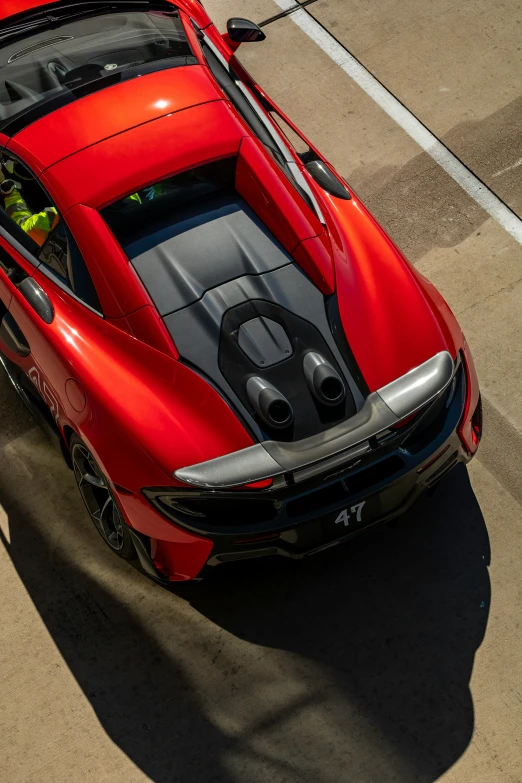 a very nice looking red car on a sunny day