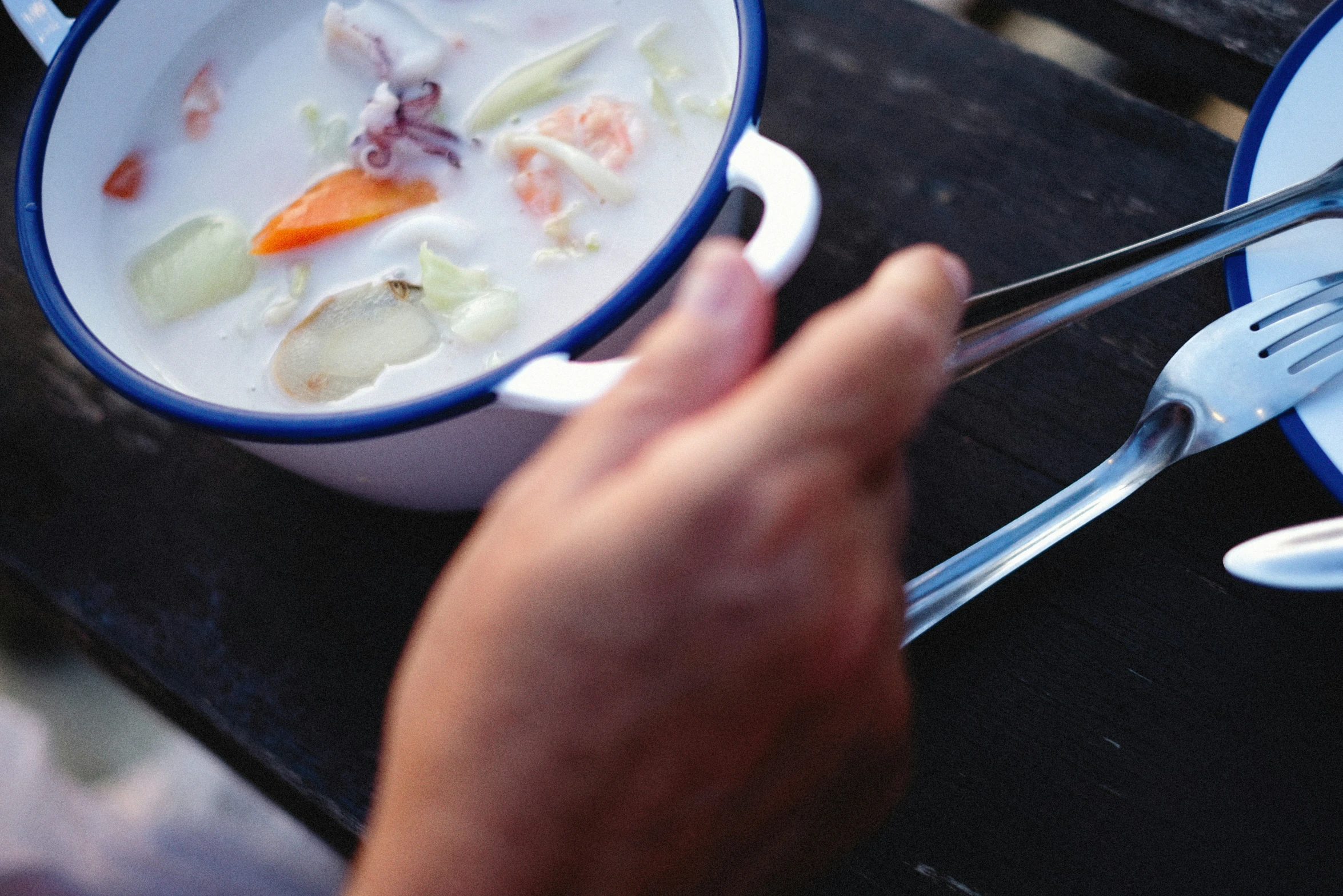 a white bowl filled with soup next to a blue plate