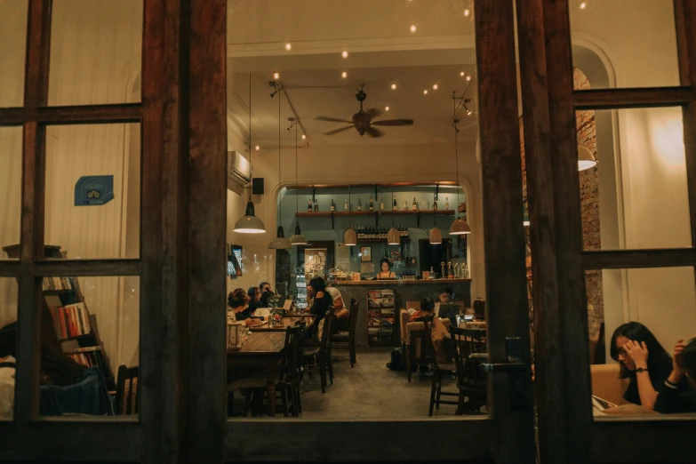 people sitting and standing at tables in a restaurant