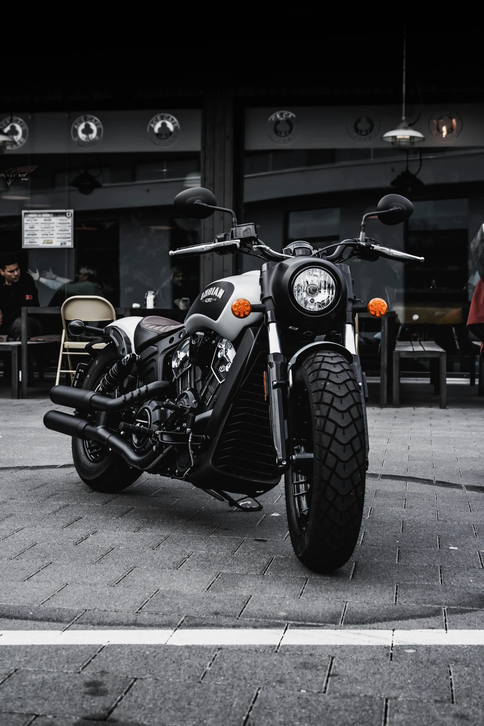 the motorcycle is parked on the brick sidewalk