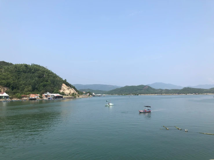 boats float across the blue, tranquil lake