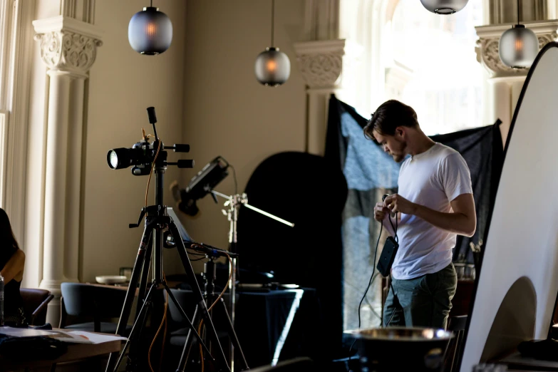 a man with a camera in his hand and a light on the other side