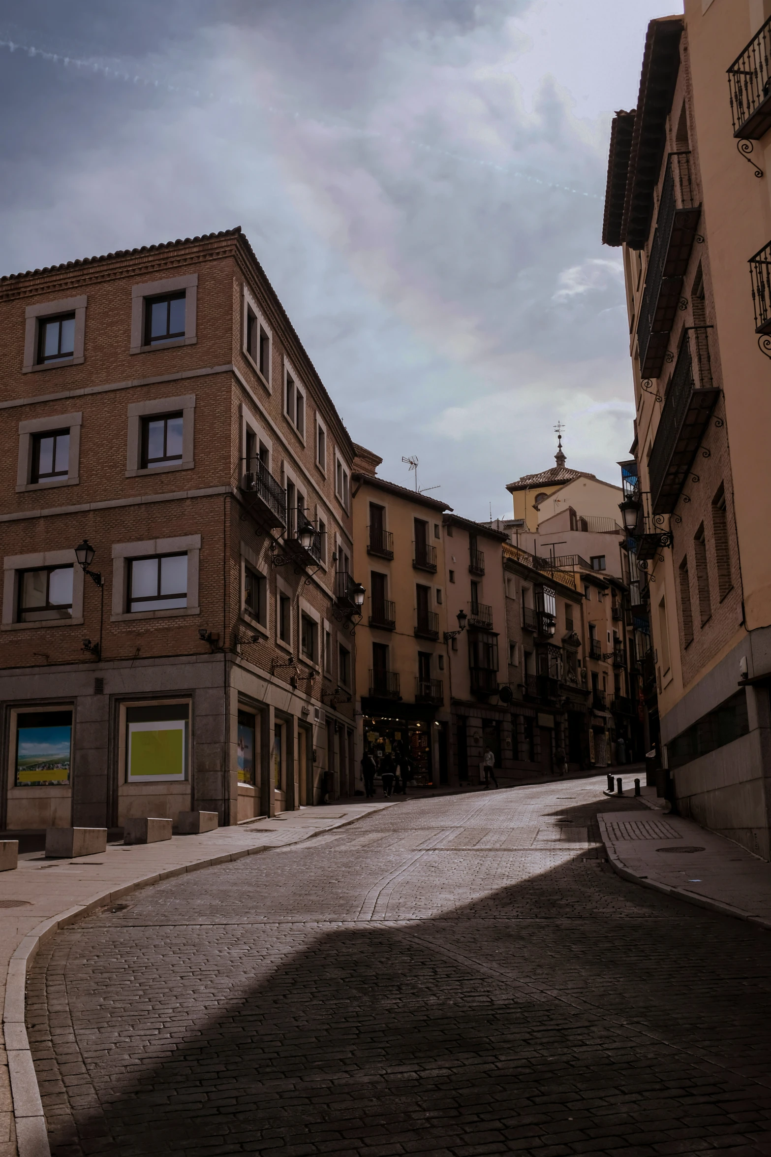 a narrow cobbled street leads to an apartment building