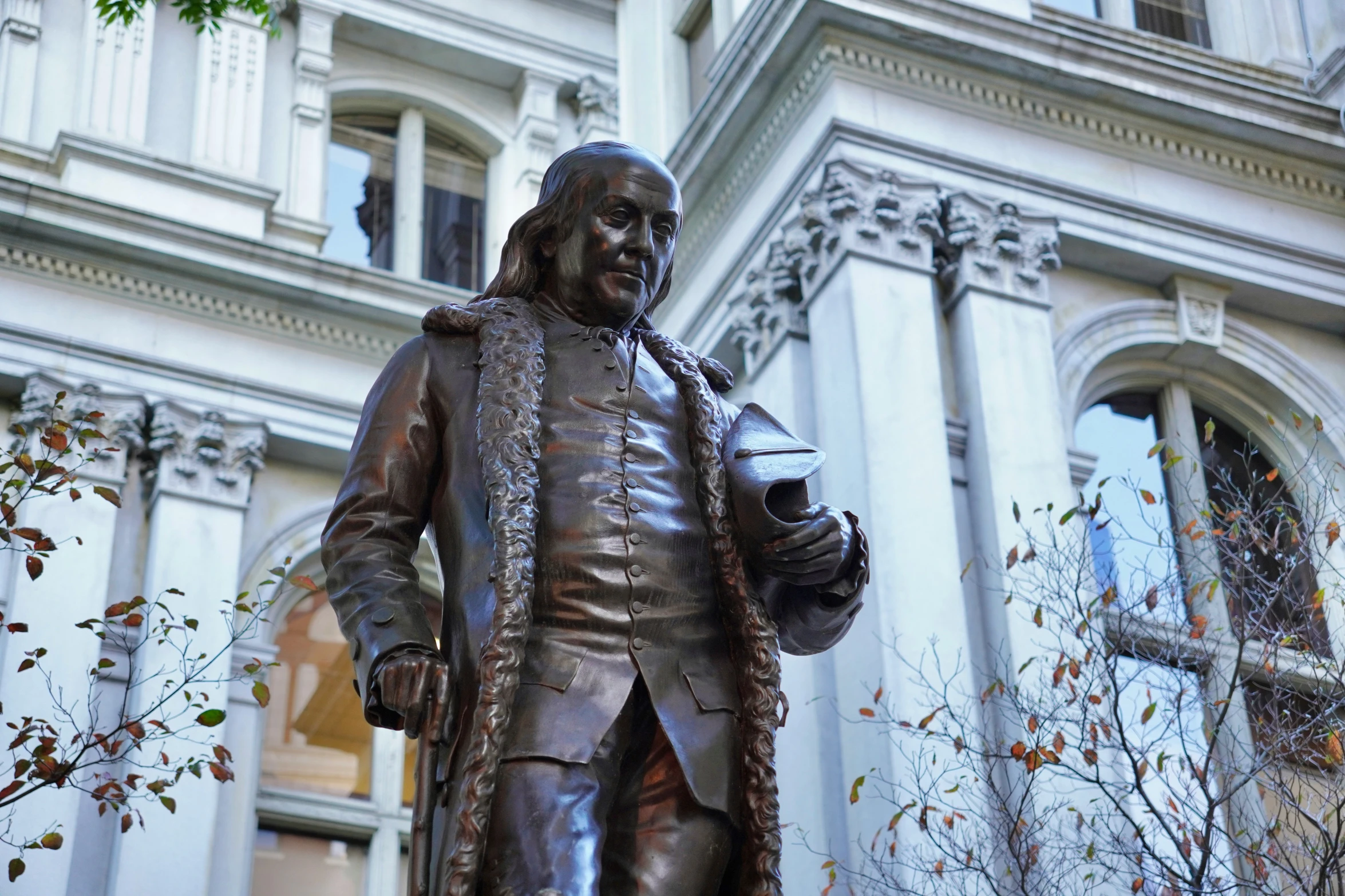 a statue of a person dressed in armor in front of a building