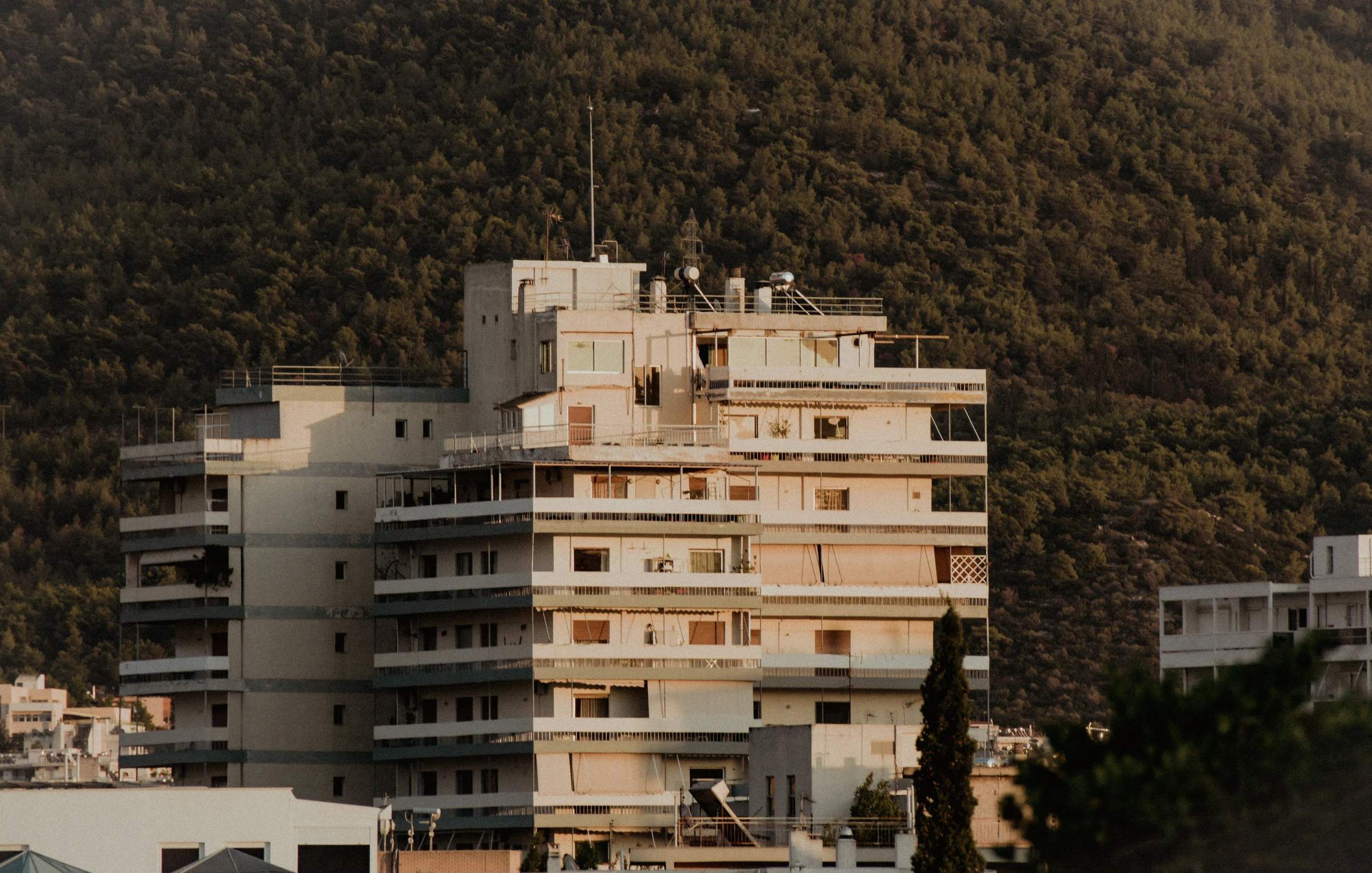 an apartment building stands near some large buildings