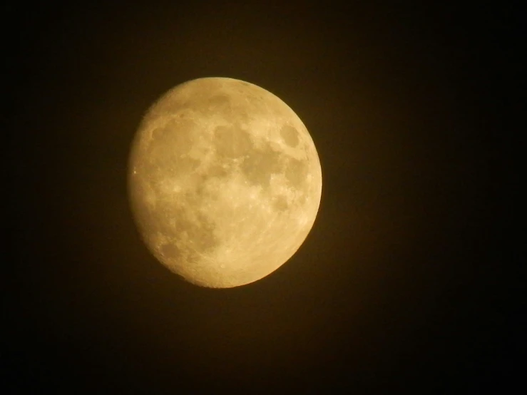 the full moon is seen through some black clouds