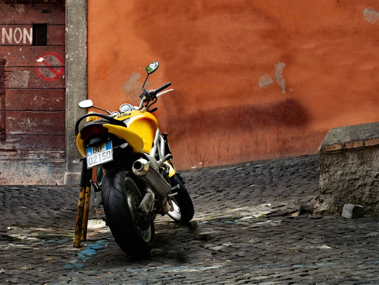 motorcycle parked on street next to building and cement ground