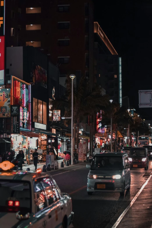 cars driving through a city at night with a street sign