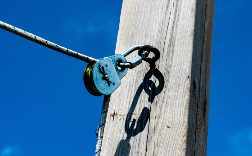 a piece of metal sitting on top of a wooden pole