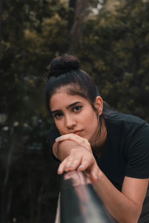 young woman leaning on rail outdoors looking back