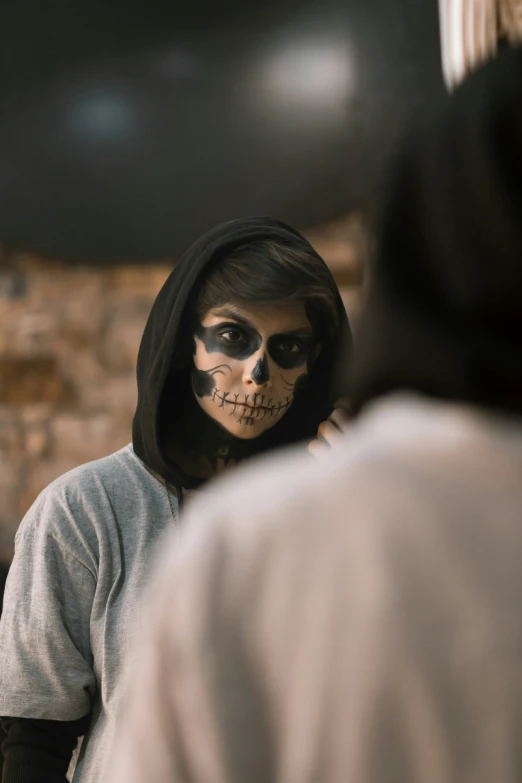 a person with skeleton makeup looks into a mirror