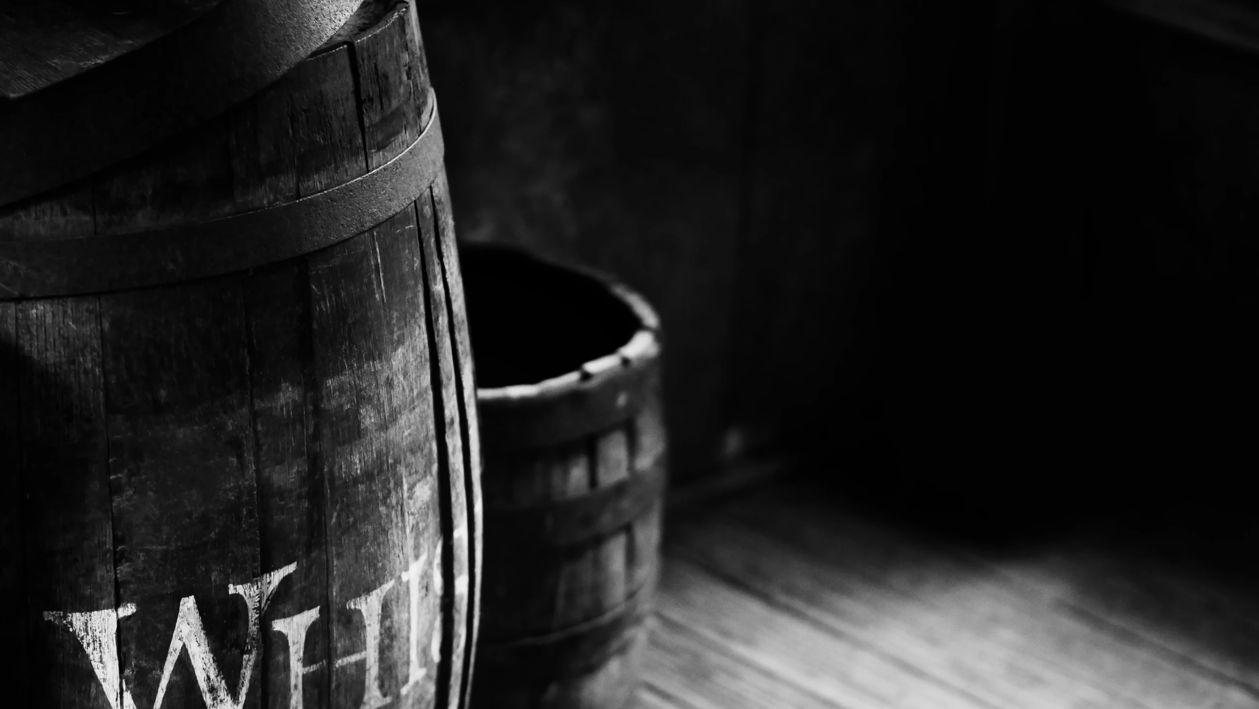 two empty wooden barrels sitting on top of a wooden floor