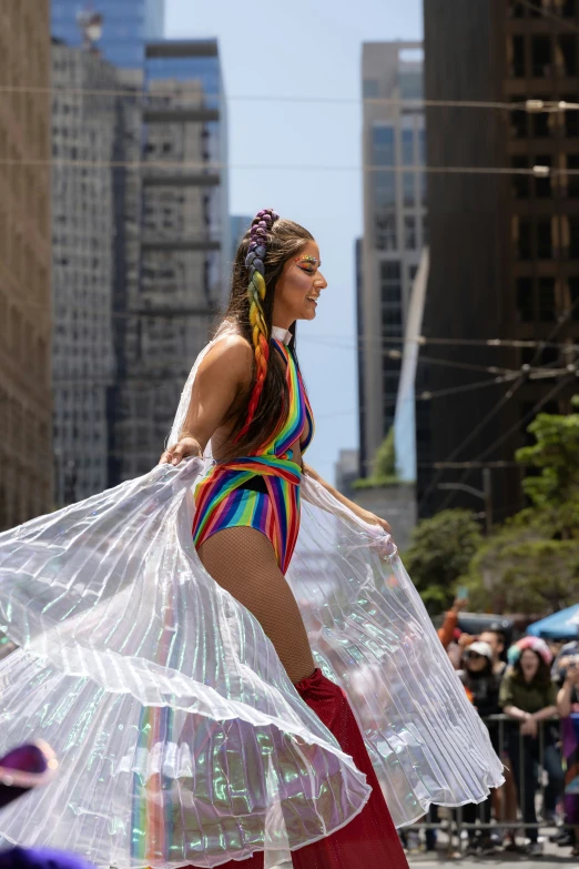 a woman wearing a dress and a long scarf in the street