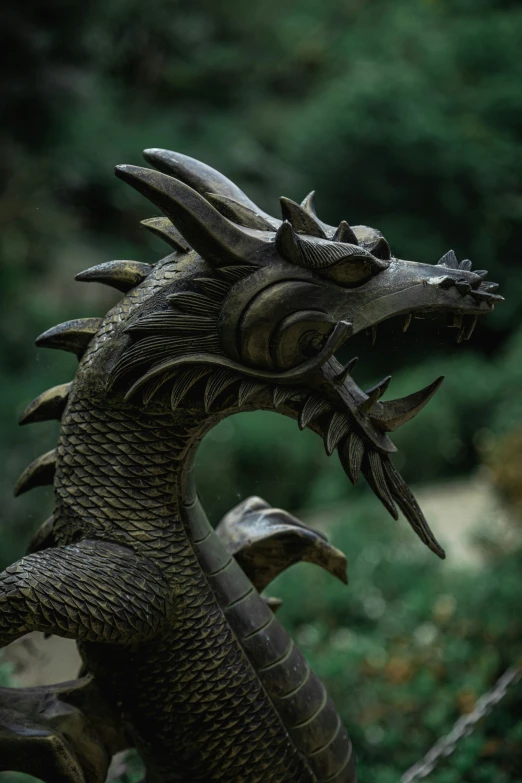 a bronze sculpture of a dragon with large fangs