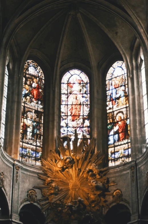 stained glass windows above the altar with chandelier